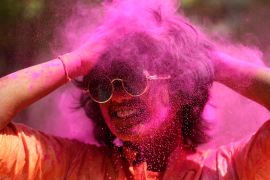 A reveller smeared in colored powder dances during Holi festival in Hyderabad, India, Friday, March 18, 2022. Holi also heralds the arrival of spring. (AP Photo/Mahesh Kumar A.)