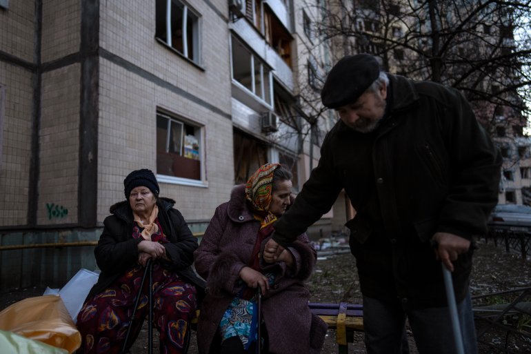 People gather outside their destroyed buildings after a bombing in Satoya neighborhood in Kyiv, Ukraine, Sunday, March 20, 2022. (AP Photo/Rodrigo Abd)