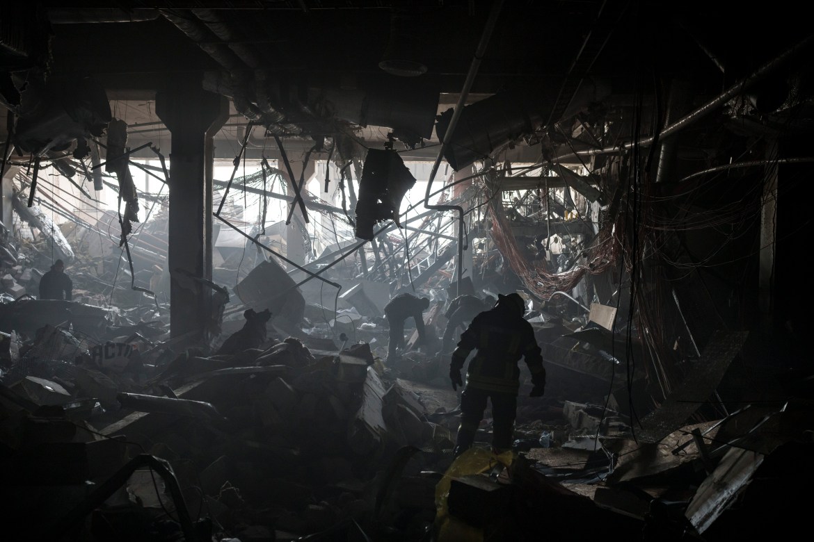 Ukrainian firefighters and servicemen search for people under debri