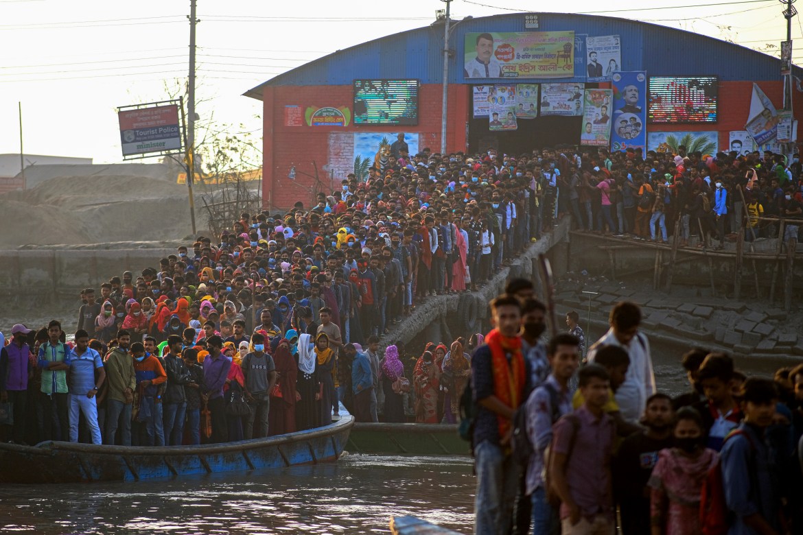 Workers gather in the morning at a boat terminal waiting to cross the Mongla river in Mongla