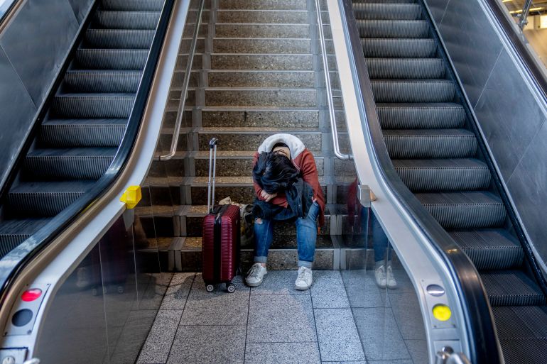 A stranded passenger rests in a terminal at the airport in Frankfurt