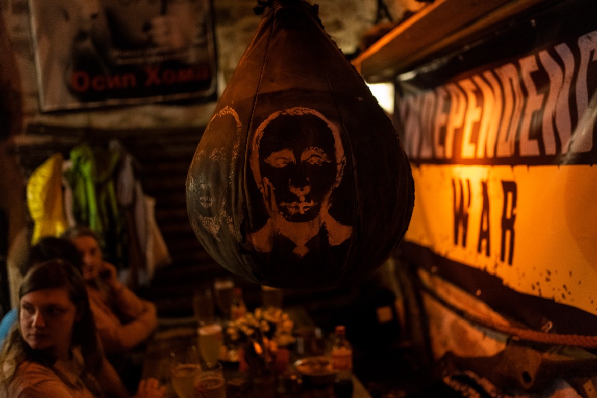 A boxing bag with a drawing of Russian President Vladimir Putin's face hangs inside a bar in downtown Lviv