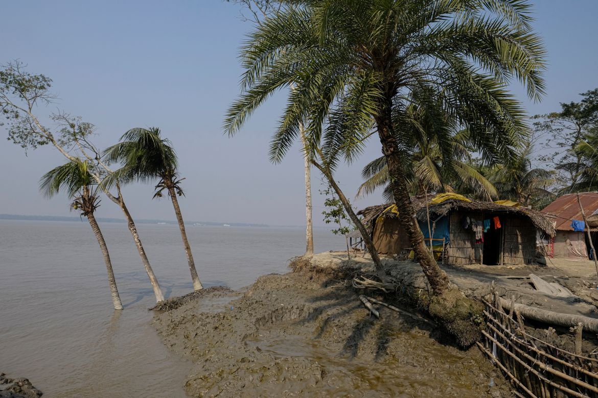 Houses and trees affected during the 2020 Cyclone Amphan sit on the water's edge at Chila Bazar in Mongla
