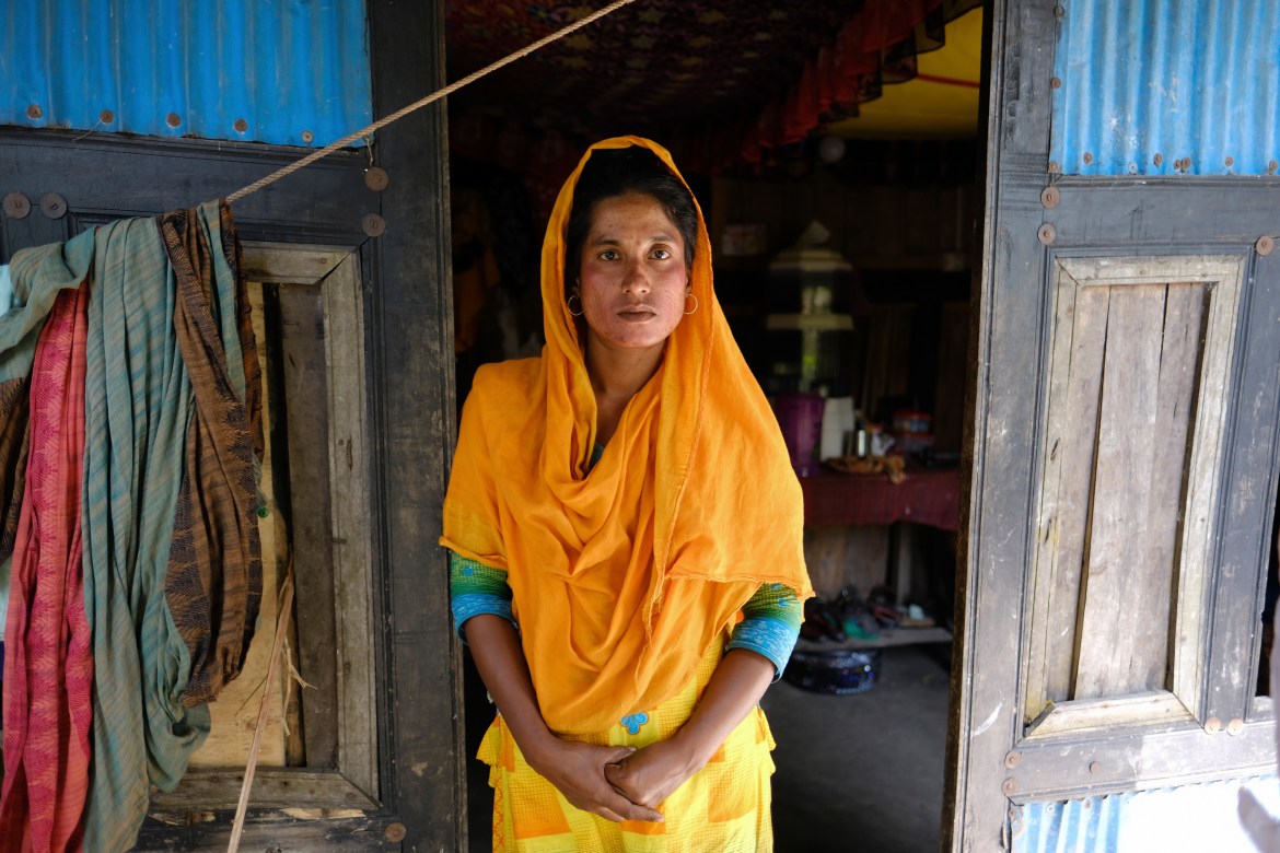 Monira Khatun, 29, stands by the door of her house in Chila Bazar, in Mongla