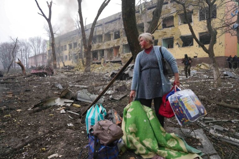 Una mujer pasa junto a una sala de maternidad dañada por una bomba en Mariupol, Ucrania.