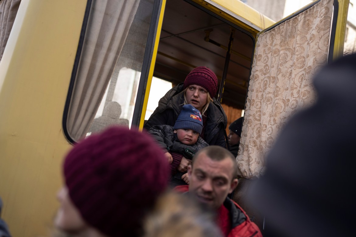 Displaced people disembark from a damaged bus upon their arrival at the Ukrainian Red Cross center in Mykolaiv