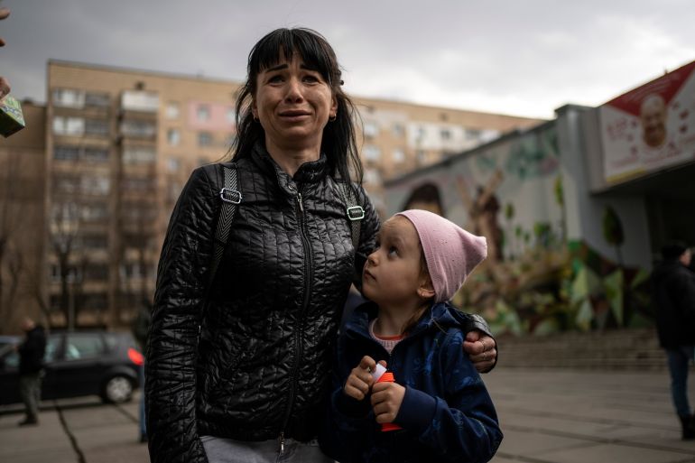 Julia, 34 , cries next to her daughter Veronika, 6, while talking to the press in Brovary, on the outskirts of Kyiv, Ukraine, Tuesday, March 29, 2022. (AP Photo/Rodrigo Abd)