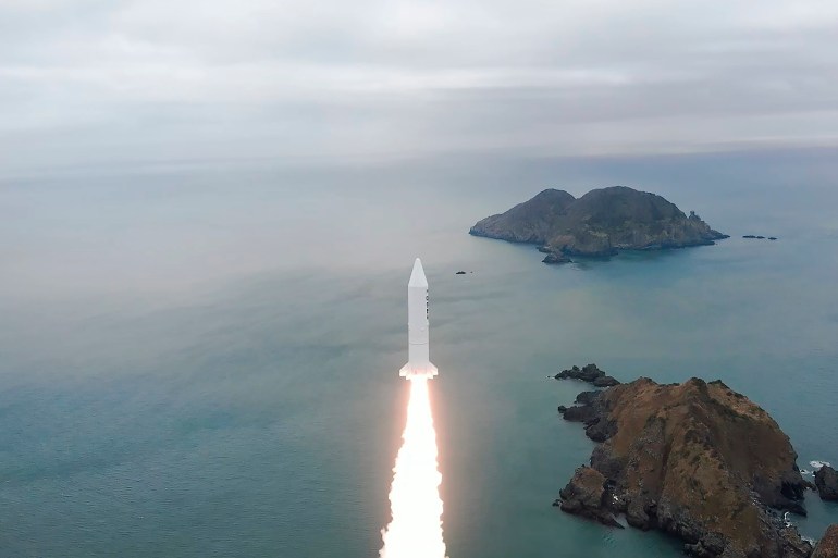South Korea's solid-fuel rocket is launched at an undisclosed coastal location with the sea and an island in view in South Korea