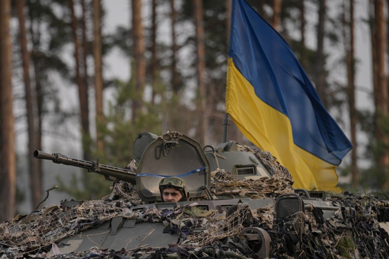 Militares ucranianos abordan un transporte blindado de personal que pasa por una posición rusa invadida por las fuerzas ucranianas en las afueras de Kiev.