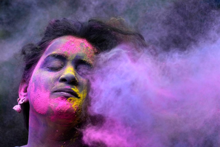 A woman smeared with colors play Holi, the Hindu festival of colors, in Mumbai, India