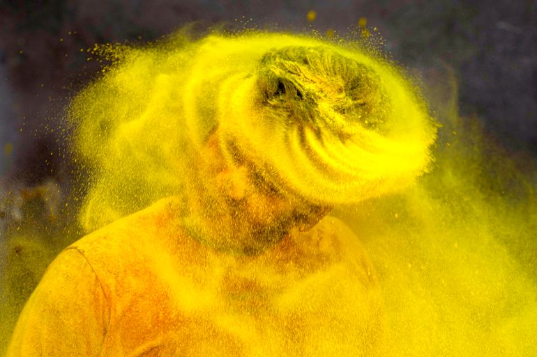 A trainer at a gymnasium plays Holi, the Hindu festival of colors, in Prayagraj, in the northern Indian state of Uttar Pradesh