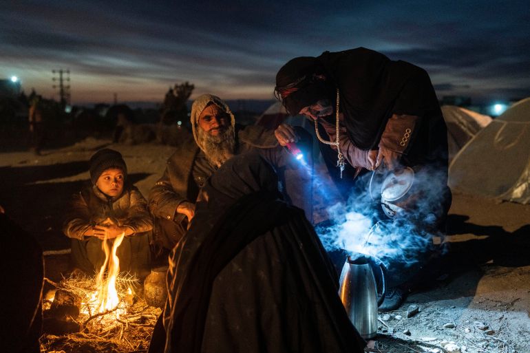 A family prepares tea outside the Directorate of Disaster office where they are camped, in Herat, Afghanistan