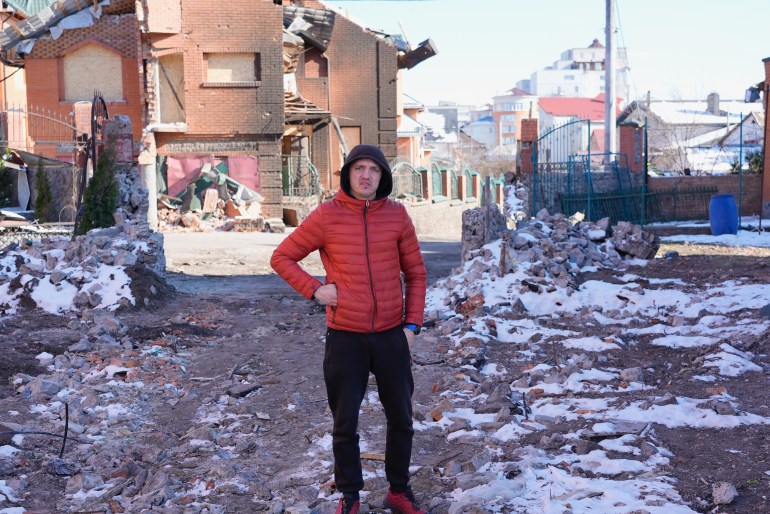 A man in front of a bombed building in Ukraine
