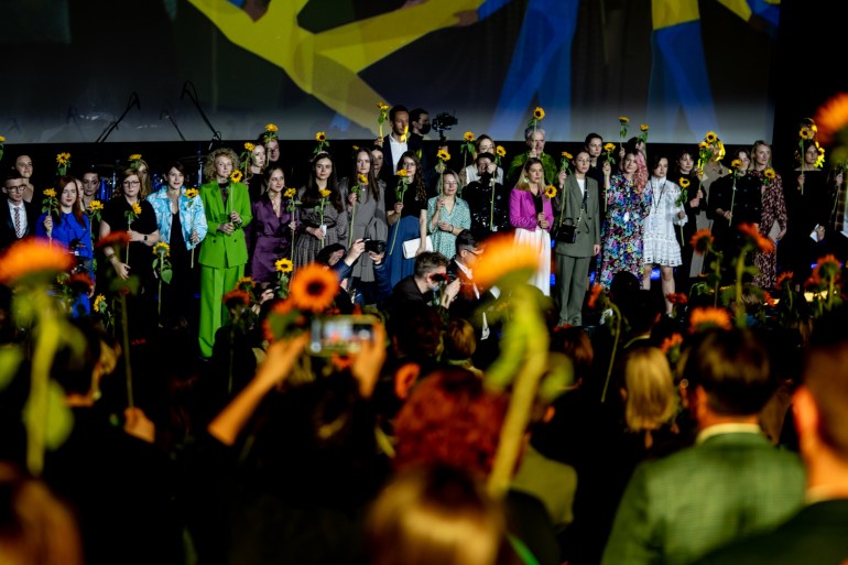 People hold sunflowers, Ukraine's national flower, at the film festival's opening ceremony