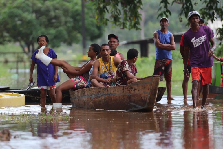 A family is seen on a boat during heavy flooding in Brazil