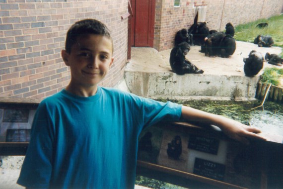 A photo of Hasan Rrahmani as a child in a zoo standing in front of apes.