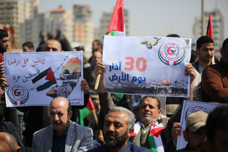 Palestinians hold banners on land day