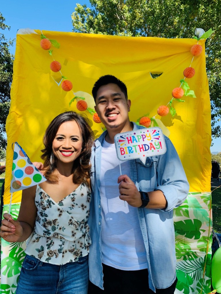 A photo of Ny Nourn, left, and Nate, right, at her birthday party holding birthday signs.