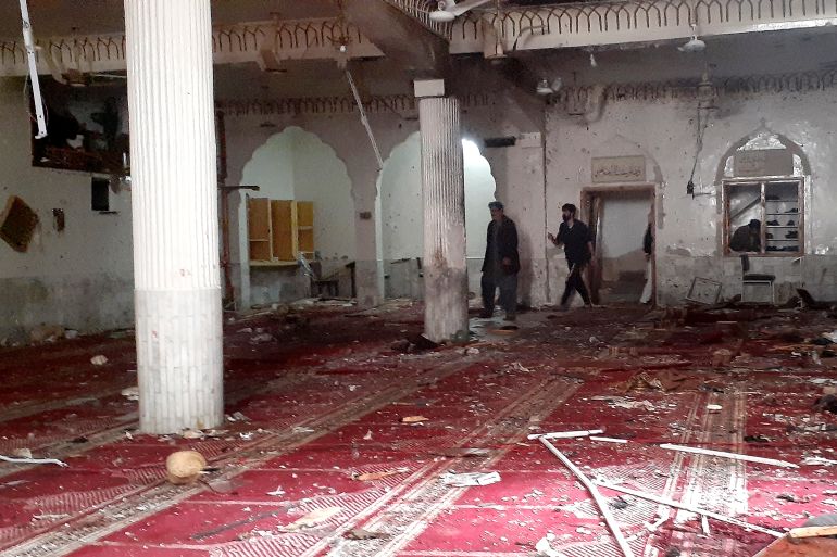 Volunteers examine the site of explosion inside a Shia mosque in Peshawar