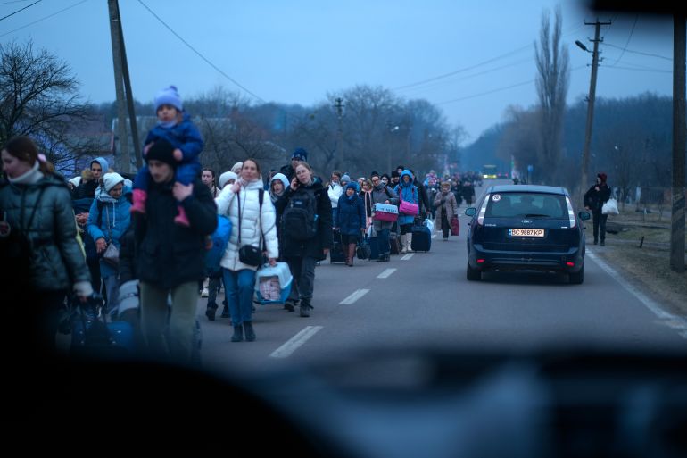 A photo of long lines of refugees wait to cross the border with Poland.