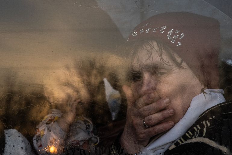 A woman sits with a baby on a bus as they flee Russian forces
