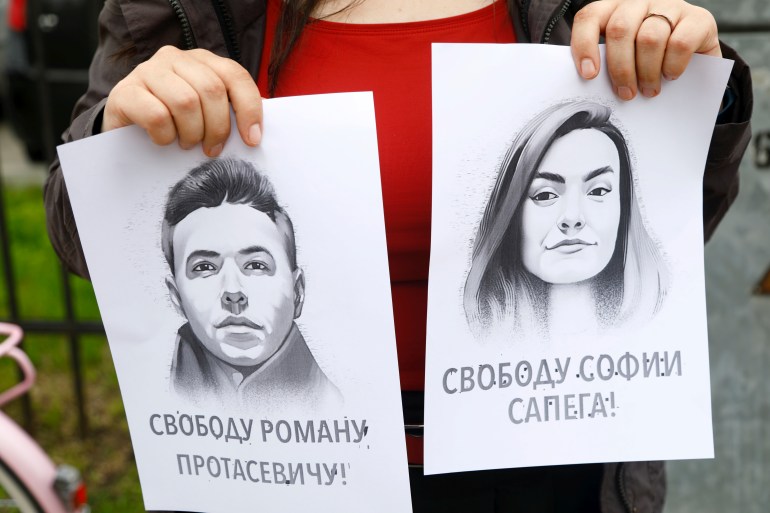 Bir kadın, 25 Mayıs 2021'de Letonya'nın Riga kentindeki Belarus büyükelçiliğinde Roman Protaseviç ile dayanışma protestosu sırasında muhalif gazeteci Roman Protasevich ve kız arkadaşı Sofia Sapega'nın portresini tutuyor. Belaruslu muhalif gazeteci Roman Protasevich
