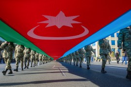 Azerbaijani soldiers carry a large national flag on the anniversary of the end of the 2020 war over the Nagorno-Karabakh region between Azerbaijan and Armenia, in downtown Baku, Azerbaijan, on November 8, 2021