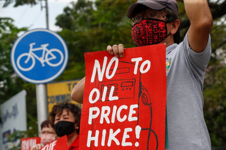 A protester holds a sign during a rally against fuel price hikes in Quezon City, Philippines