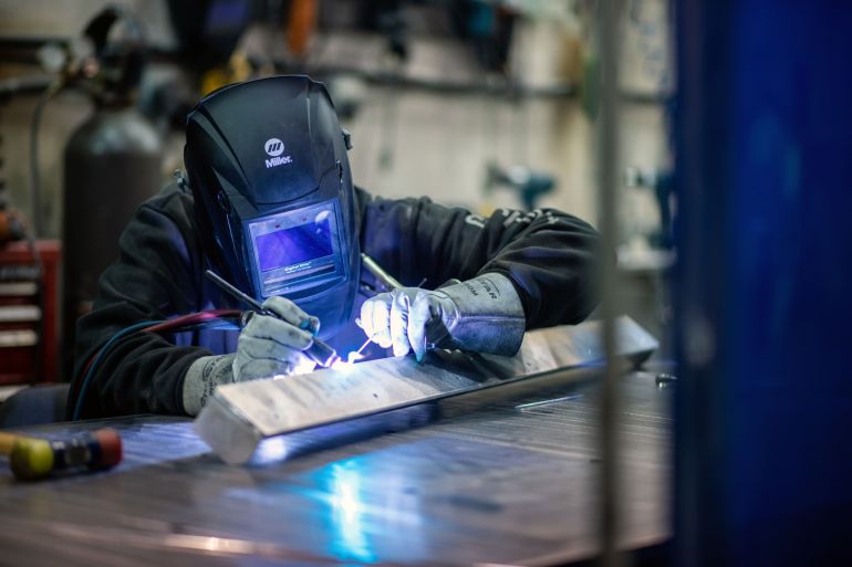 A welder works at a fabrication and welding shop in Langford, British Columbia, Canada