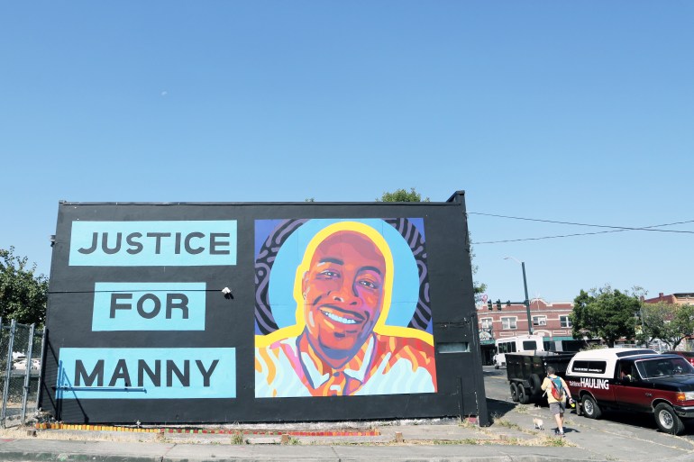 A mural depicts Manuel Ellis against a black background with the words Justice for Manny written beside it