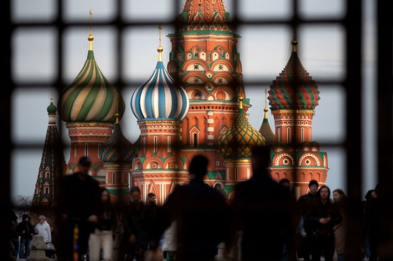 Pedestrians walk by Saint Basil's Cathedral on Red Square in Moscow, Russia