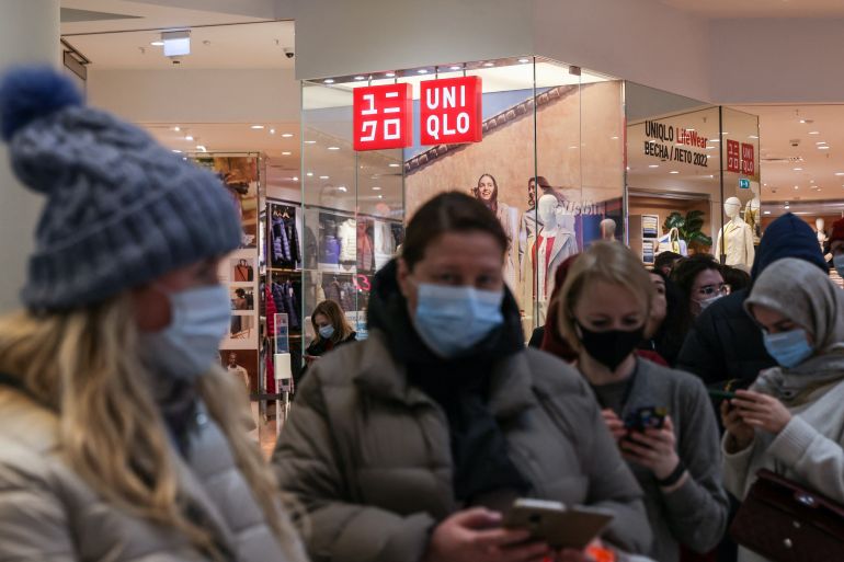 Customers queue to enter a Uniqlo store in Moscow, Russia