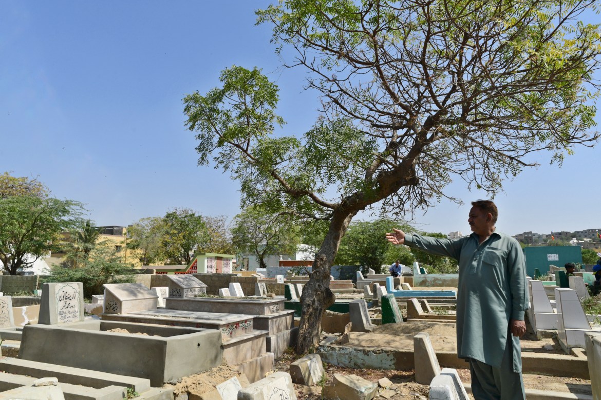 a man points to where his father's grave used to be