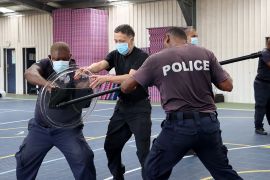 a China Police Liason Team officer (C) training local RSIPF officers in drill, unarmed combat skills