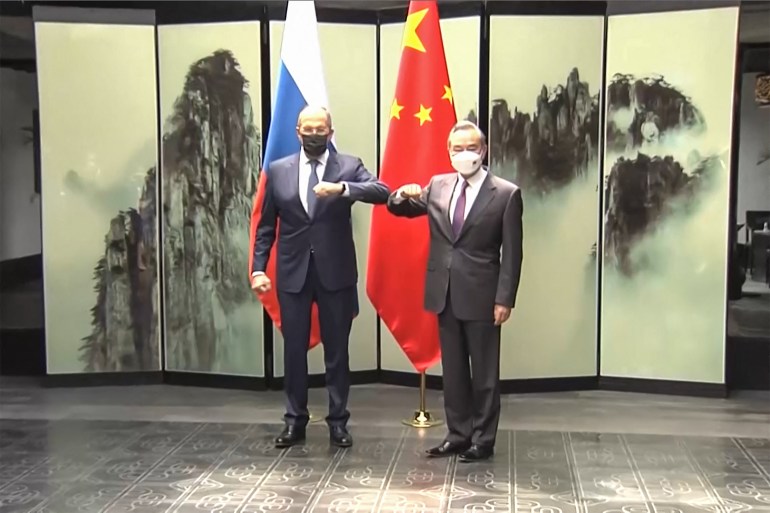 Sergey Lavrov and Wang Yi touch elbows at a meeting at the end of March in a screengrab from Chinese state media