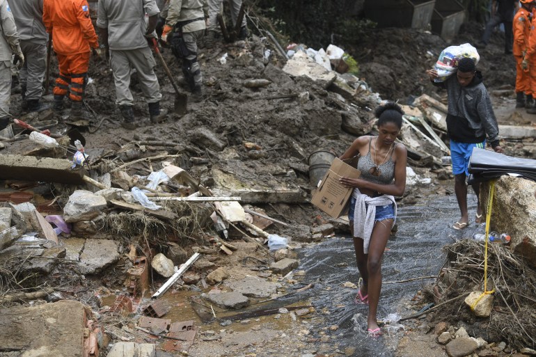 People carry belongings after a giant landslide in Caxambu neighbourhood in Petropolis