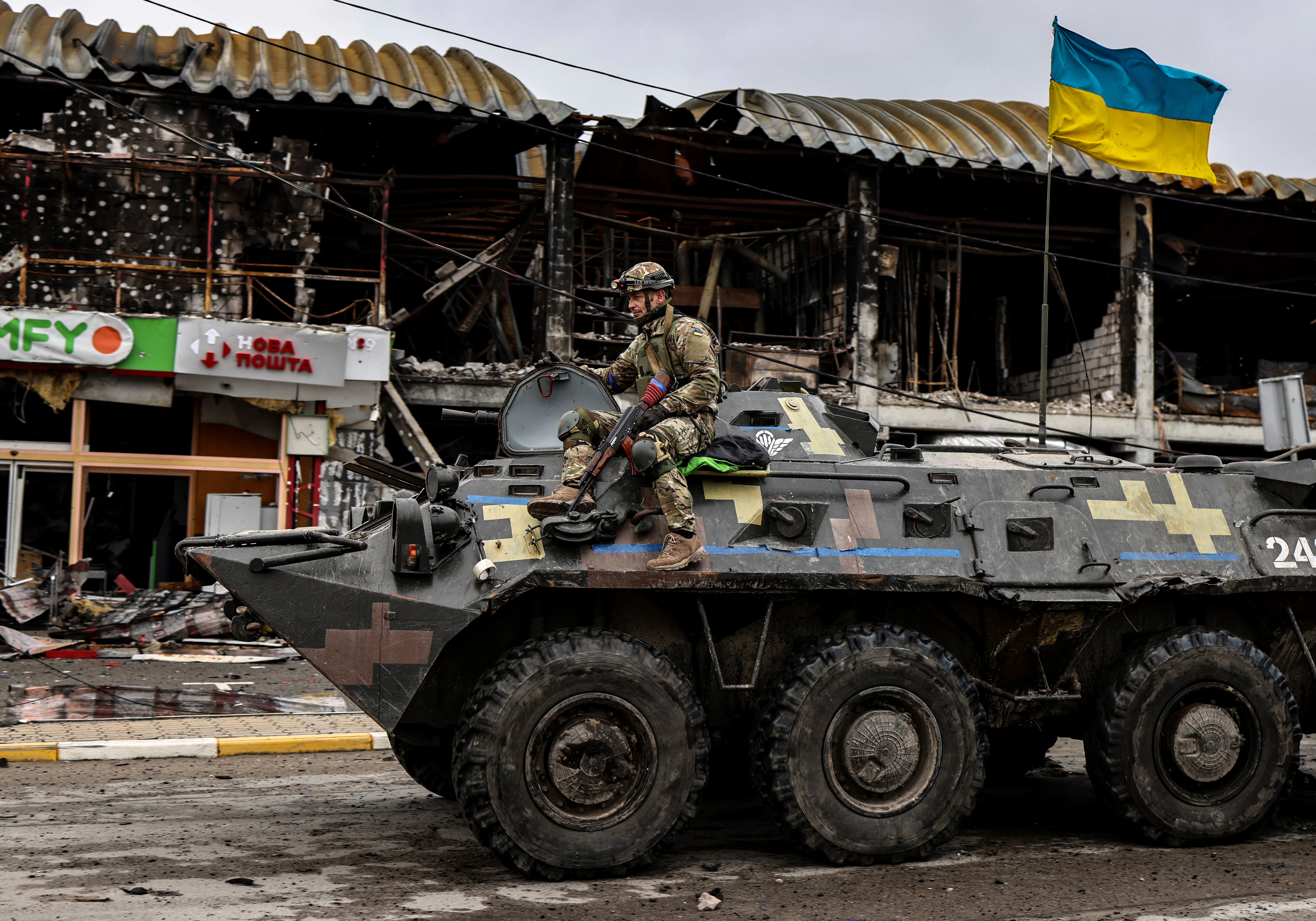 Um soldado ucraniano patrulha em um veículo blindado uma rua em Bucha, a noroeste de Kiev