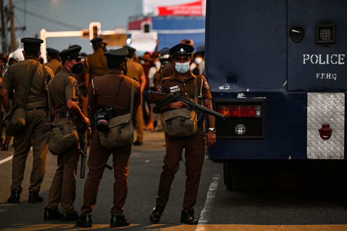 Police stand guard at a spot where protestors take part in a demonstration against the surge in prices and shortage of fuel and other essential commodities in Colombo