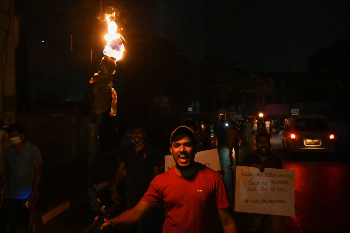 Protestors hold placards and torches during a demonstration against the surge in prices and shortage of fuel and other essential commodities in Colombo