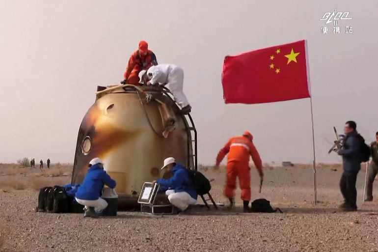 the capsule of the Shenzhou-13 spacecraft after it returned to Earth with a Chinese flag planted alongside it