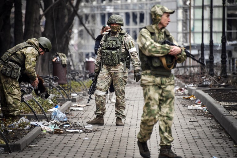 Russian soldiers patrol a street in Mariupol, Ukraine.