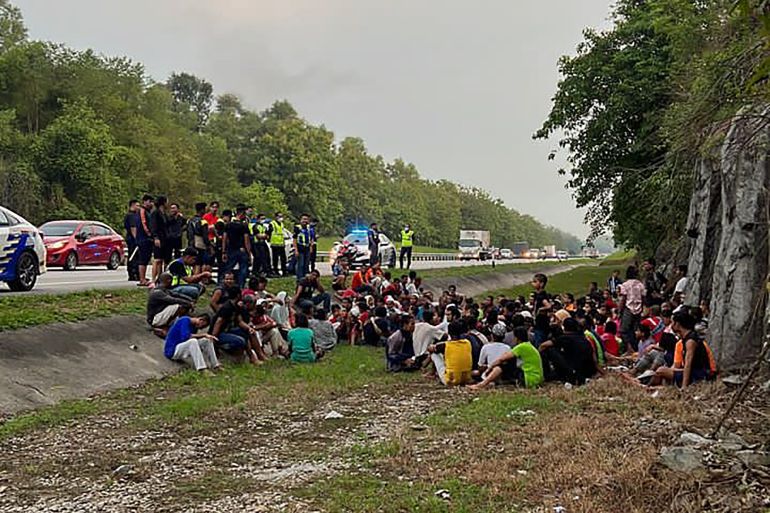 Rohingya refugees, who had escaped from Malaysian Immigration's temporary depot in northern Malaysia squat by the side of the road after being arrested by police