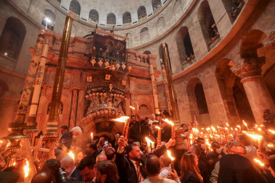 Worshippers hold lit candles
