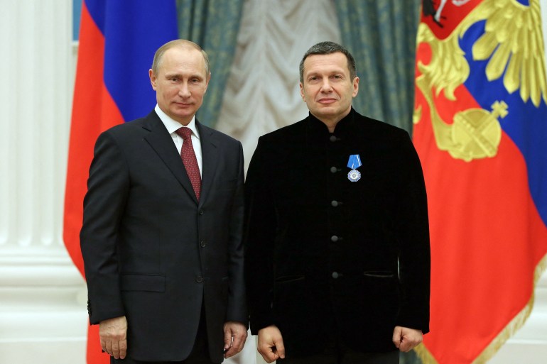 Russian President Vladimir Putin poses with TV anchor Vladimir Solovyev during an awards ceremony at the Kremlin in Moscow.