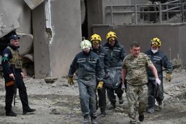 Rescuers carry a body from a damaged building following Russian strikes in Kyiv