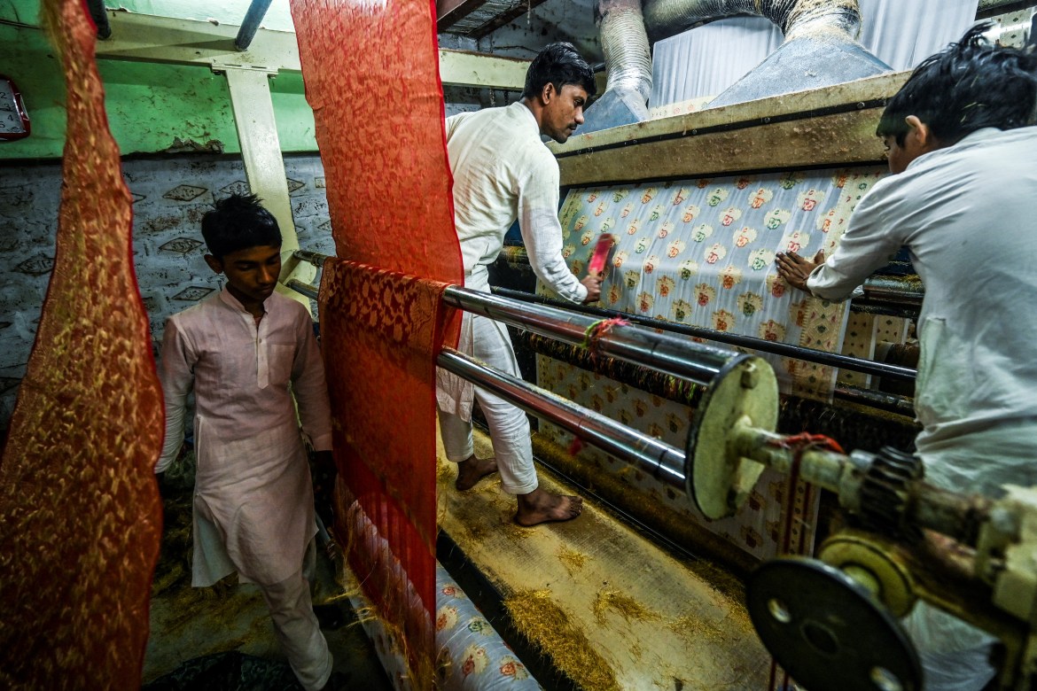 workers give final touches to a Banarasi silk sari at a workshop in Varanasi