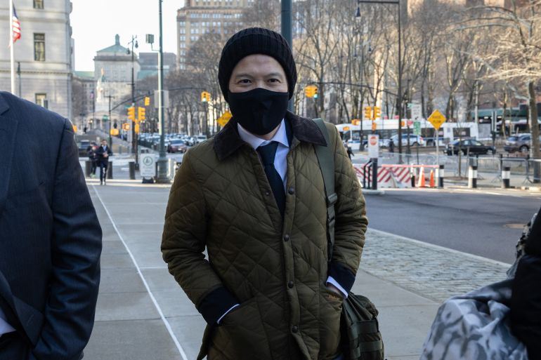 Roger Ng in woolly hat and winter coat with a bag slung across his body arrives at court in Washington DC