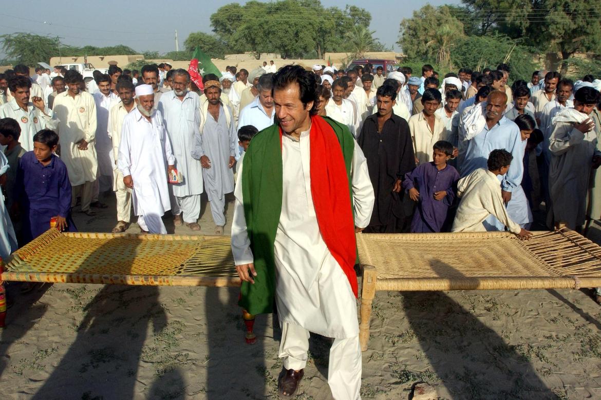 Pakistani cricket-legend Imran Khan (C) leads a small rally during his door-to-door election campaign in a remote area of Kundal