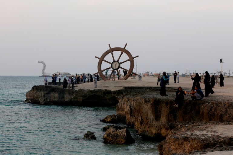 Iranians gather on the sea front during sun set in Iran's southern resort island of Kish.