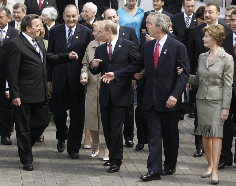 Russian President Putin points out US President Bush to German Chancellor Schroeder and French President Chirac as they walk after ceremonies in Red Square.